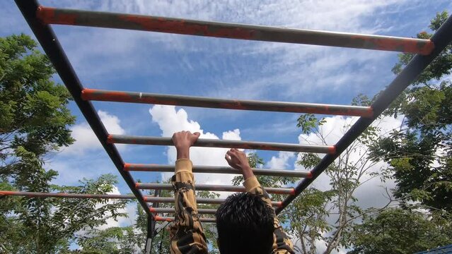 a man is in fitness with a pull up style. hold on to the iron bar shoulder-width apart in an up and down motion. upper position on the back and grip. South Kalimantan, Indonesia. &lrm;July &lrm;16, &lrm;2022.