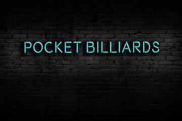 Night view of neon sign on brick wall with inscription pocket billiards