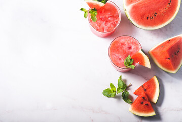 Watermelon summer smoothie, fresh juice and mint on colorful blue wooden background. Sweet summer dessert, smoothie, cocktail healthy food concept, copy space. Summertime, top view