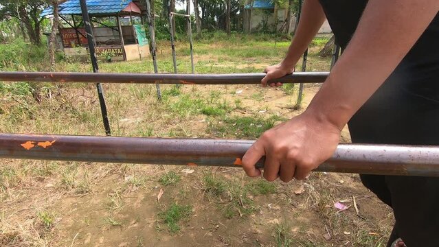 a man is in fitness with a pull up style. hold on to the iron bar shoulder-width apart in an up and down motion. upper position on the back and grip. South Kalimantan, Indonesia. &lrm;July &lrm;16, &lrm;2022.
