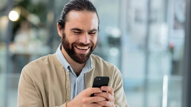 Happy entrepreneur using a phone and receiving an instant loan approval. Successful business man checking text message or email with a happy expression on his face after reading good news online