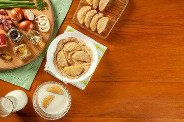 Concept of breading brazilian meat stuffed croquette (risolis de carne) on a wooden table. Top view.