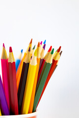 Many colored pencils close-up on a white background. Selective focus
