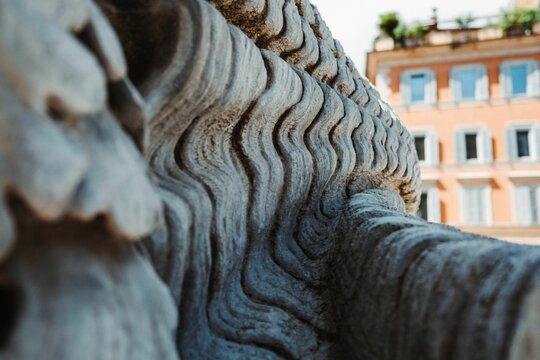 Closeup shot of the details of an architectural monument with a building in the background
