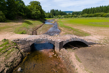 An old, usually submerged bridge at a near empty reservoir during a heatwave