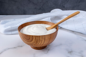 Greek yogurt in wooden bowl