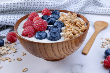 Serving yogurt with blueberry raspberry and oat flakes