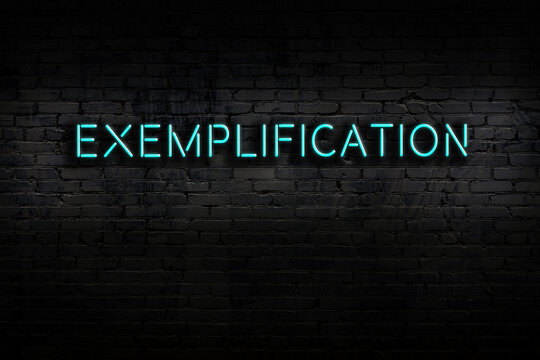 Neon sign. Word exemplification against brick wall. Night view