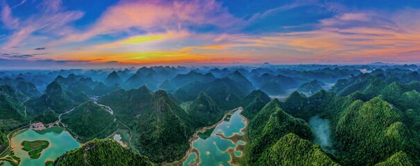 Aerial view of the mountains surrounded by a river at sunset in Yangshuo County, China