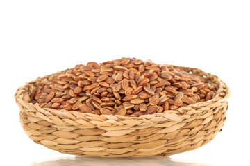 Organic uncooked brown rice in a straw plate, close-up, isolated on white background.