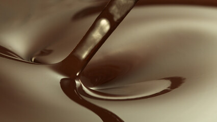Close-up of stirring stream of melted chocolate.