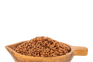 Organic uncooked brown rice in a wooden cup, close-up, isolated on white background.