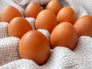 group of  brown chicken eggs on a grey table linen cloth