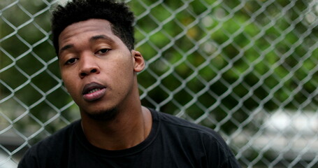 Portrait young black man looking at camera outside. Mixed race african male