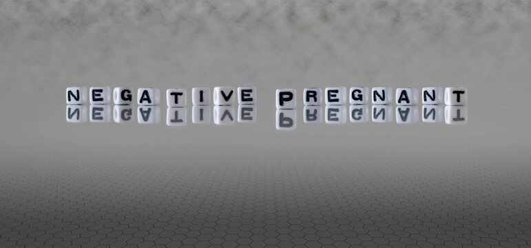 negative pregnant word or concept represented by black and white letter cubes on a grey horizon background stretching to infinity