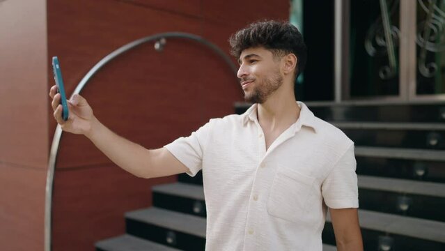 Young arab man smiling confident making selfie by the smartphone at street