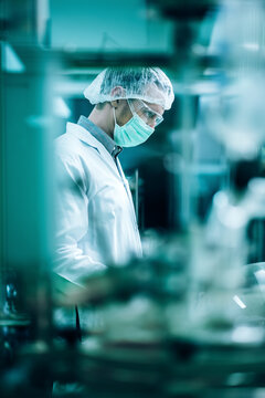 Caucasian man scientist in lab coat, researcher working in laboratory with cannabis oil CBD extraction machine, Chemical lab test on cannabis oil, CBD, THC, alternative medical.