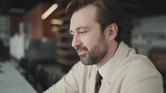 Pleased brunet businessman listening his colleague and agrees in the office 