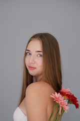 Fototapeta premium Portrait of pretty young woman with pink and red chrysanthemum flowers