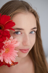 Portrait of pretty young woman with pink and red chrysanthemum flowers