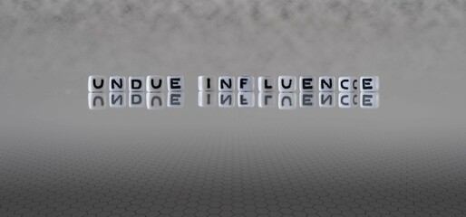 undue influence word or concept represented by black and white letter cubes on a grey horizon...