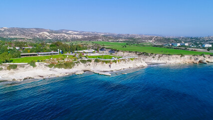 Aerial view of coastline and landmark big white chalk rock at Governor's beach,Limassol, Cyprus. Steep stone cliffs and deep blue sea waves next to Kalymnos fish restaurant and vasilikos power station