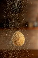 Uncooked brazilian croquette stuffed with cheese been breading with breadcrumbs.