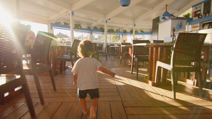 4 sibling boys look at the camera smiling, play while running through a restaurant in front of the camera, eat ice cream, hug their mother