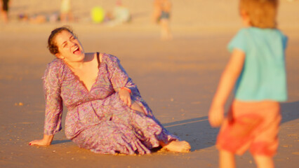 Wonderful family - father, mother and 4 sons (1-8 years old) - walk along one of the most beautiful beaches of Cádiz at sunset - they love and hug each other, look after their children