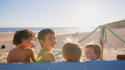 Wonderful family - father, mother and 4 sons (1-8 years old) - walk along one of the most beautiful beaches of Cádiz at sunset - they love and hug each other, look after their children