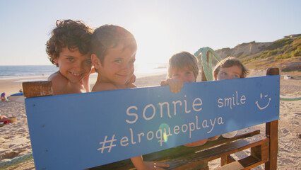 Wonderful family - father, mother and 4 sons (1-8 years old) - walk along one of the most beautiful beaches of Cádiz at sunset - they love and hug each other, look after their children