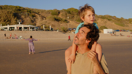 Wonderful family - father, mother and 4 sons (1-8 years old) - walk along one of the most beautiful beaches of Cádiz at sunset - they love and hug each other, look after their children