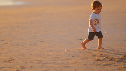 Wonderful family - father, mother and 4 sons (1-8 years old) - walk along one of the most beautiful beaches of Cádiz at sunset - they love and hug each other, look after their children