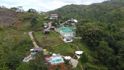 High-angle shot of a rural mountain resort with pools and cabanas