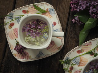 French cup with lilac petals on the table