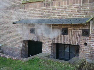 View of the steam leakage ventilation in the basement of a brick building