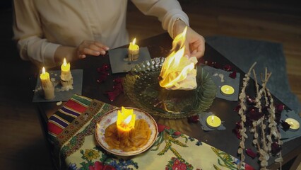4K. Top view of the table with candles. Women's hands set fire to paper