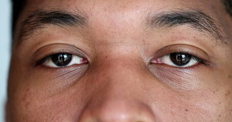 Close-up young black man eyes looking at camera, macro african person face