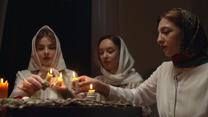 4K. Slavic women are guessing with a ring in a dark room by candlelight