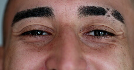 Obraz premium Close-up hispanic eyes closing and opening eyes in meditation. Smiling latino man