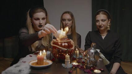 4K. Three female witches in a dark room conduct mystical sessions