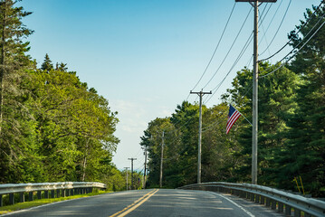 Fototapeta na wymiar Country main road fading into the horizon distance on a blue sky day, Maine