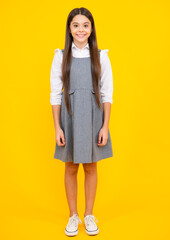 School uniform. Teenager child girl casual clothes posing isolated on yellow background in studio. Kids lifestyle concept.