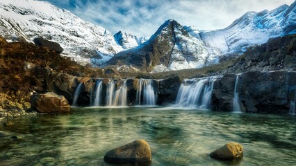 Scenic view of the Fairy Pools waterfall in Scotland surrounded by snowy mountains.