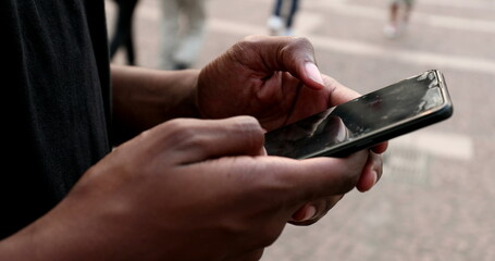 Black african person hands using smartphone browsing and touching screen