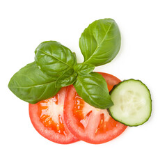 tomato and cucumber slices, basil leaves  on a white background close up, top view