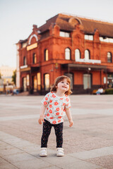 little girl walking and playing on the street in summer