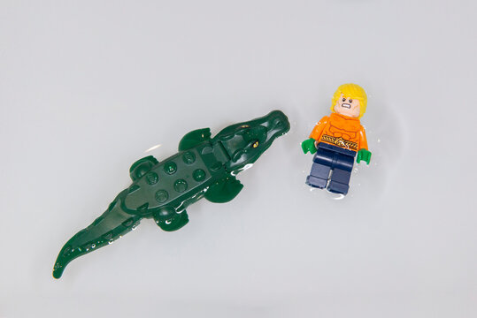Top view of Aquaman angry swimming belly up with big fierce crocodile