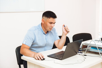 an Asian man is working at a computer .the student is studying, studying online.business concept of technological devices