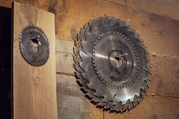 set of circular saw blades hangs on a wooden wall in the carpentry workshop. Circular saw. old rustic carpentry workshop.